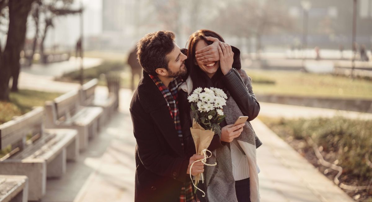 Mand Overrasket kvinde med blomster til Valentinsdag